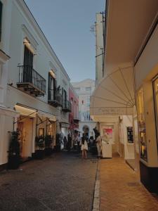 a little girl walking down a street with an umbrella at Pied-à-Terre in Piazzetta in Capri