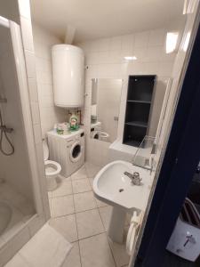 a bathroom with a sink and a washing machine at Nuage climatisé in La Tremblade