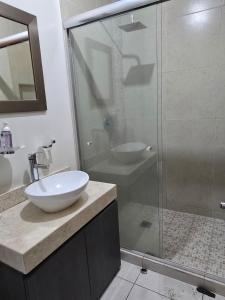 a bathroom with a glass shower and a sink at Pozos Comfort House in San Luis Potosí
