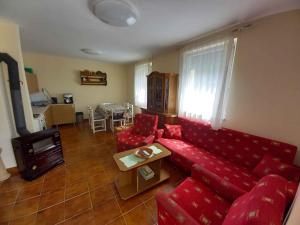 a living room with a red couch and a table at Holiday home in Badacsony - Balaton 18019 in Badacsony