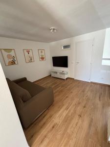 una sala de estar con un sofá y un televisor en Casa Milele, en Viareggio