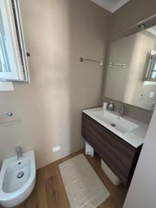 a bathroom with a sink and a toilet and a mirror at Casa Milele in Viareggio +5 photos