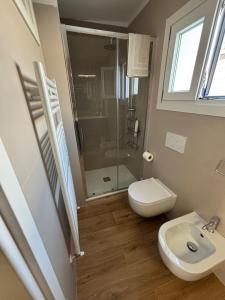 Un baño con ducha, inodoro y lavabo. en Casa Milele, en Viareggio