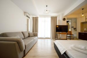 een woonkamer met een bank en een televisie bij SeaZen Studio in Mamaia Nord – Năvodari