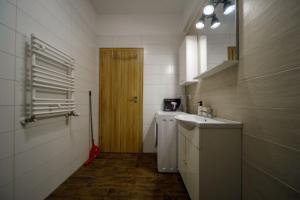 een badkamer met een wastafel en een houten deur bij SeaZen Studio in Mamaia Nord – Năvodari +10 foto's