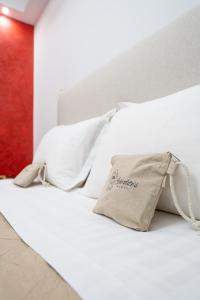 a bed with white pillows and a bag on it at Aphrodites House Upon White Tower in Thessaloniki +27 photos
