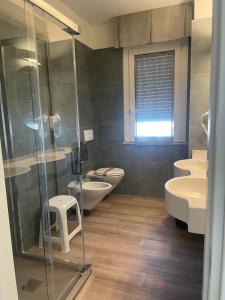 łazienka z toaletą i przeszklonym prysznicem w obiekcie Hotel Il Caminetto w mieście Porto San Giorgio