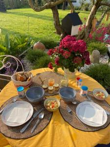 a table with plates and bowls of food on it at Ty Glazu Doelan espace 60m2, Port& criques à pied, 2 chambres privées au 1er étage, SDB, WC séparé in Clohars-Carnoët