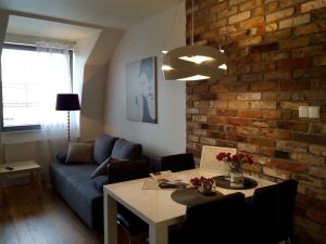 グダニスクにあるGdansk Tartaczna Premium Apartmentの青いソファとレンガの壁が備わるリビングルーム