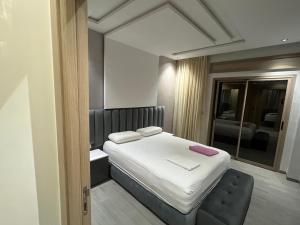 a bedroom with a white bed and a mirror at Najla Sh in Tangier