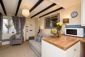 une cuisine et un salon avec un canapé et une table dans l'établissement Dolls Cottage, à Looe