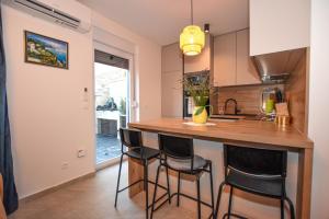 a kitchen with a bar with stools in it at Apartment T E A Pag with HOT TUB in Pag