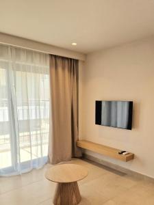 a room with a tv and a table and a window at NAMI Seaside in Kokkini Khanion +26 photos