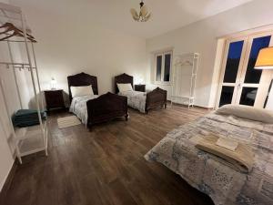 a bedroom with two beds and two chairs in it at Tenuta Nissole in Rocchetta Tanaro