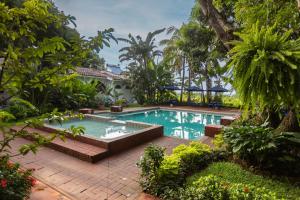 a swimming pool in the middle of a garden at Hotel Las Marías in Taxisco
