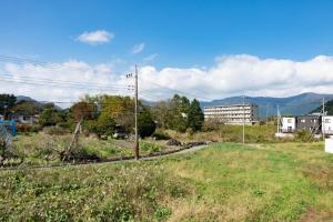 a field of grass with a building in the background at Private House Fuji - Vacation STAY 74689v in Azagawa