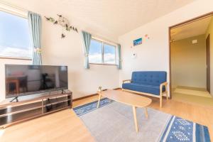 a living room with a tv and a blue chair at Private House Fuji - Vacation STAY 74689v in Azagawa