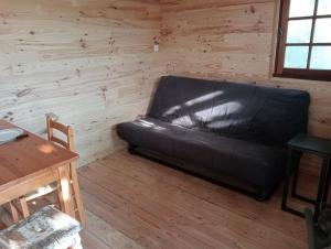 a leather couch sitting in a room with a table at cabane perchée et le chêne in Saint-Roch