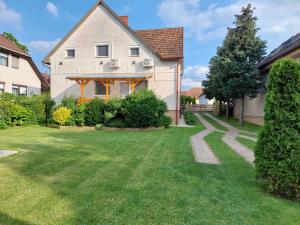 dom z ogródkiem z zieloną trawą w obiekcie Apartment Balatonszarszo/Balaton 20083 w mieście Balatonszárszó