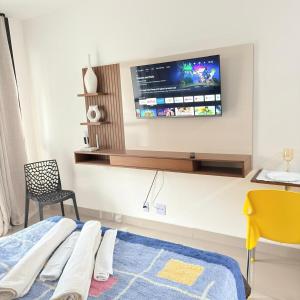 a bedroom with a bed and a tv on the wall at 74NV Studio Liberdade SP 300 metros Estação Metrô Japão até 03 pessoas in Sao Paulo