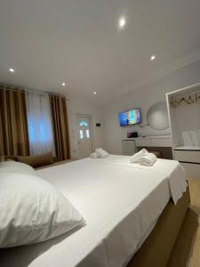 a bedroom with two beds and a tv on the wall at Odore di Mare 2 in Qeparo