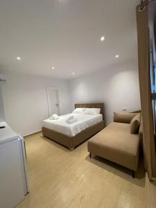 a bedroom with a large bed and a couch at Odore di Mare 2 in Qeparo