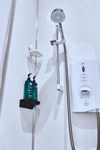 a shower with two bottles on a shelf in a bathroom at West Beach 1 - dog friendly - Portrush by the Sea in Portrush
