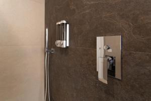 a bathroom with a soap dispenser on a wall at Cagliari Essence - Boutique Stay in the Heart of Cagliari in Cagliari +49 photos