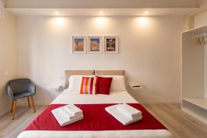 a bedroom with a bed with a red blanket at Cagliari Essence - Boutique Stay in the Heart of Cagliari in Cagliari