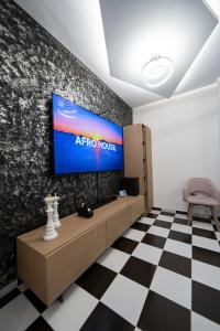 a room with a tv and a checkered floor at Aphrodites House Upon White Tower in Thessaloniki
