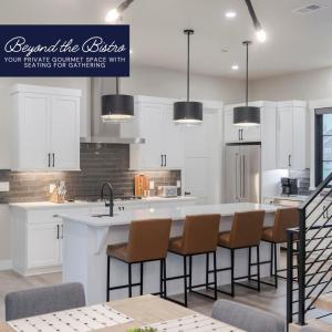 a kitchen with white cabinets and a large island with chairs at Gather & Glow in Winter Park