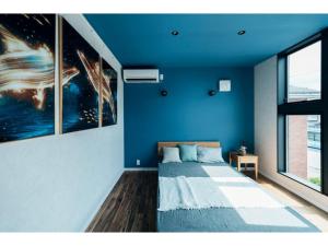 a bedroom with a blue wall with a bed in it at Manhattan Hills Toyama - Vacation STAY 05553v in Toyama