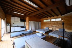 a room with three beds and a kitchen at TOWA BEACH HOUSE IRITAHAMA - Vacation STAY 06102v in Shimoda