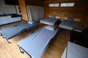a room with three beds and a kitchen at TOWA BEACH HOUSE IRITAHAMA - Vacation STAY 06102v in Shimoda