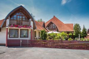 une maison avec une clôture devant dans l'établissement Apartments in Balatonkeresztur 36528, à Balatonkeresztúr