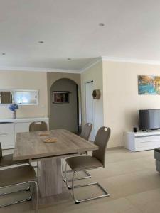 a dining room with a wooden table and chairs at Maison vacances - cure thermale in Eugénie-les-Bains +2 photos
