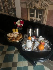 a table with two trays of breakfast food on it at La suite Isabelle de Luxembourg in Béthune