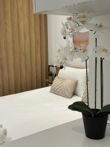 a bedroom with a bed with white sheets and a plant at Diamond 3 in Kallithea Halkidikis +22 photos