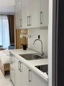 a kitchen with white cabinets and a sink at Diamond 3 in Kallithea Halkidikis
