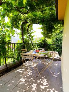 a table and chairs sitting on a balcony with trees at La Casa del Sole in Carrodano Inferiore