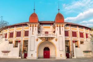 a large building with a red door and a balcony at L'Aurore - Terrasse - Duplex - Parking in Dax