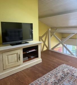 a living room with a flat screen tv on a cabinet at L'Aurore - Terrasse - Duplex - Parking in Dax