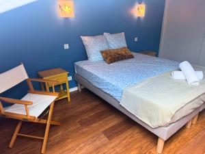 a small bedroom with a bed and a chair at L'Aurore - Terrasse - Duplex - Parking in Dax +35 photos