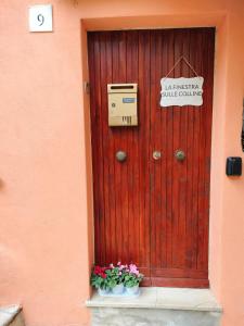 a wooden door with a sign on it next to flowers at La finestra sulle colline in Torre Orsina