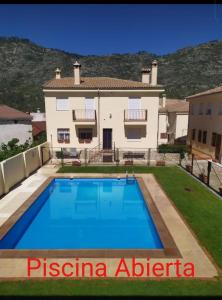 una villa con piscina frente a una casa en Alojamiento valeria, en Arroyo Frío