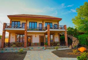 a house with a balcony on top of it at Merebashvili Estate in Kaspi