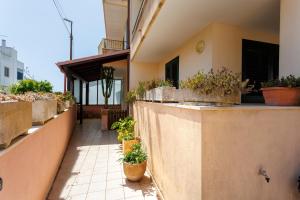a balcony with potted plants on the side of a building at Green Tulip - Beauty Apartment with Garden in Uggiano la Chiesa