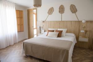 1 dormitorio con 1 cama blanca grande con almohadas marrones en La Toscana Casa Rural piscina ,parking ,barbacoa, en Jadraque