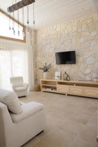 sala de estar con TV en una pared de piedra en La Toscana Casa Rural piscina ,parking ,barbacoa, en Jadraque