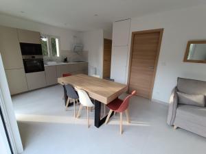 a kitchen and dining room with a wooden table and chairs at Maison T2 avec jacuzzi in Ensuès-la-Redonne